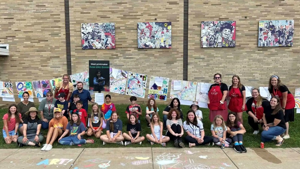 art students and teachers with mural backdrop at paw paw middle schools
