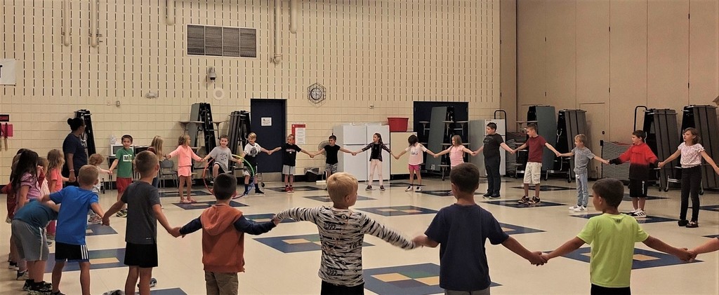 Kids holding hands in a circle at the Later Elementary.