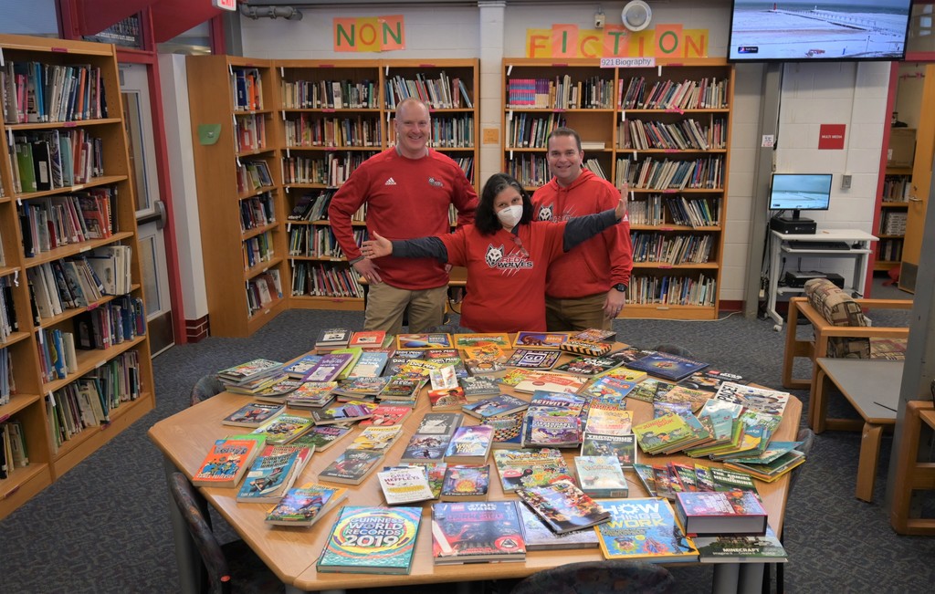 2 men and a woman with library books