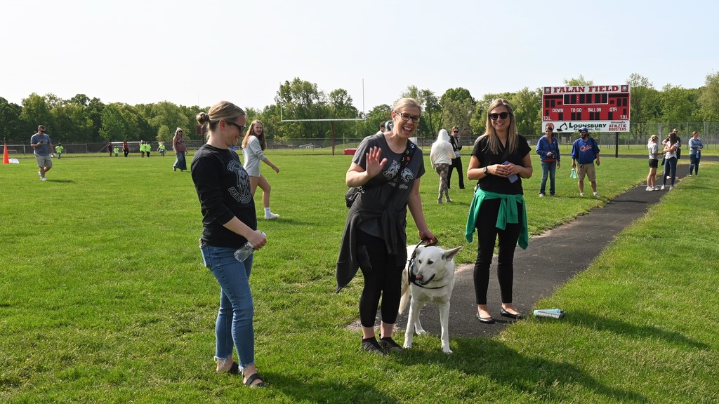 3 school staff members outside with therapy dog at Falan Field