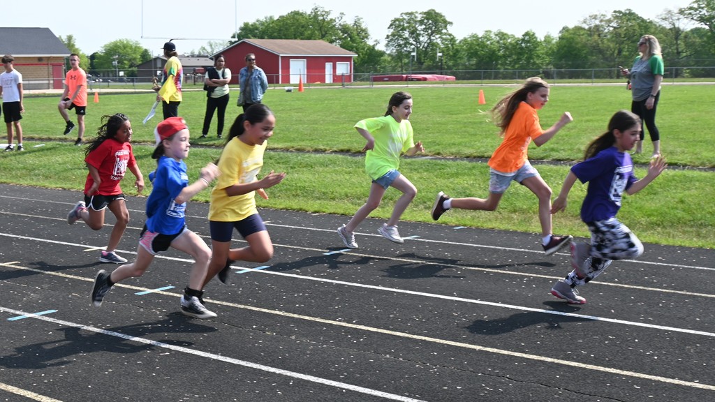 elementary students running in relay race at Falan Field