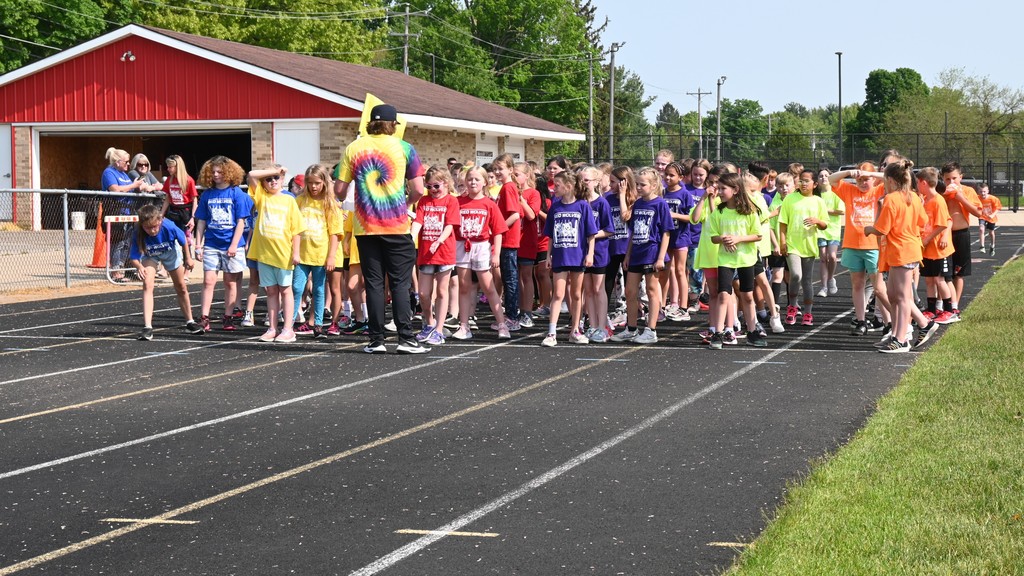 elem. students running outside on school track