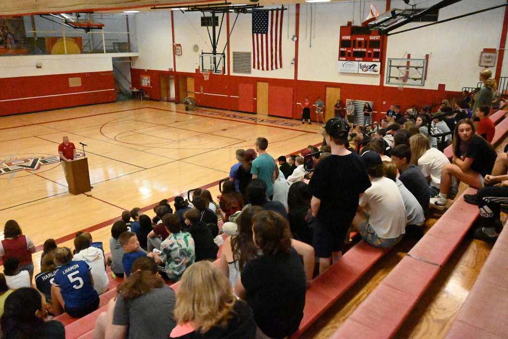principal speaking in gymnamius to middle school students in bleachers