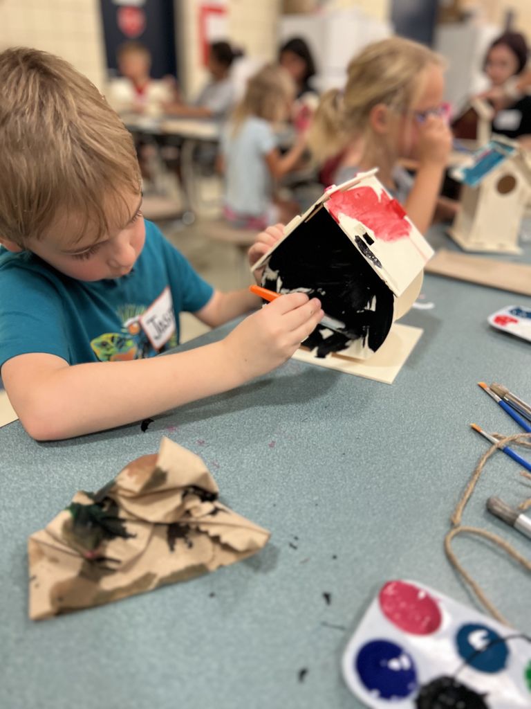 boy painting birdhouse